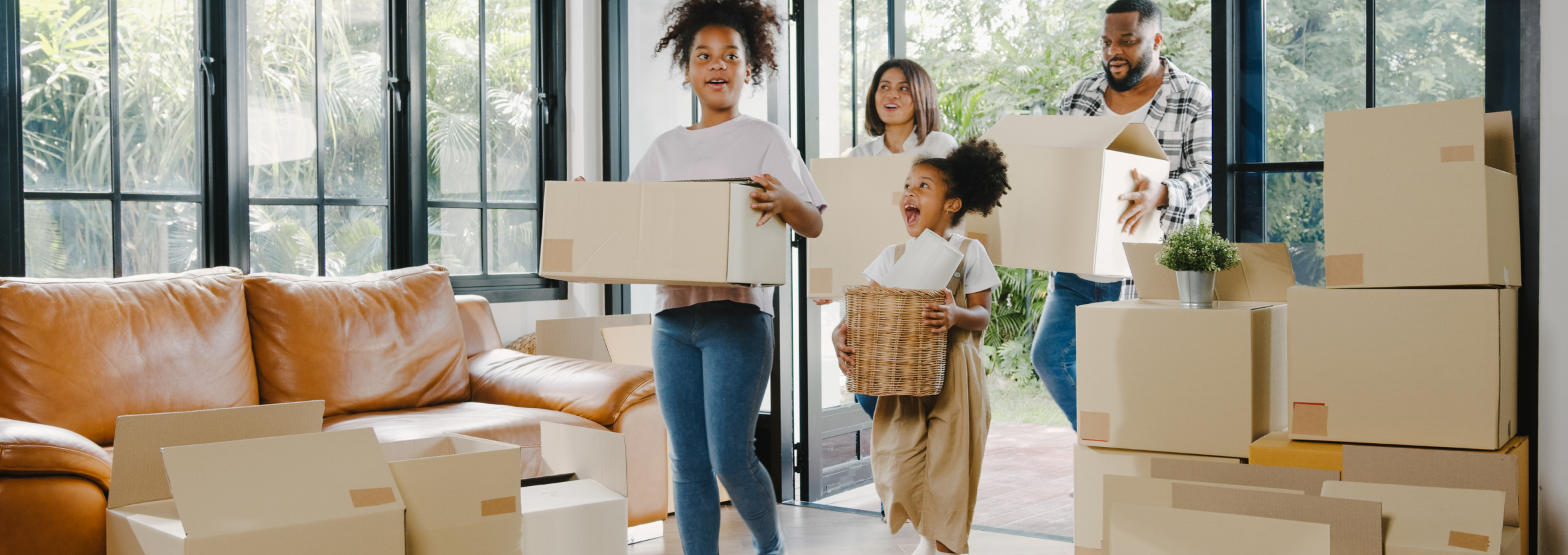 A joyful family carrying boxes into their new home
